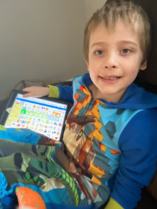 Braiden with his LAMP Words for Life app asking for a book